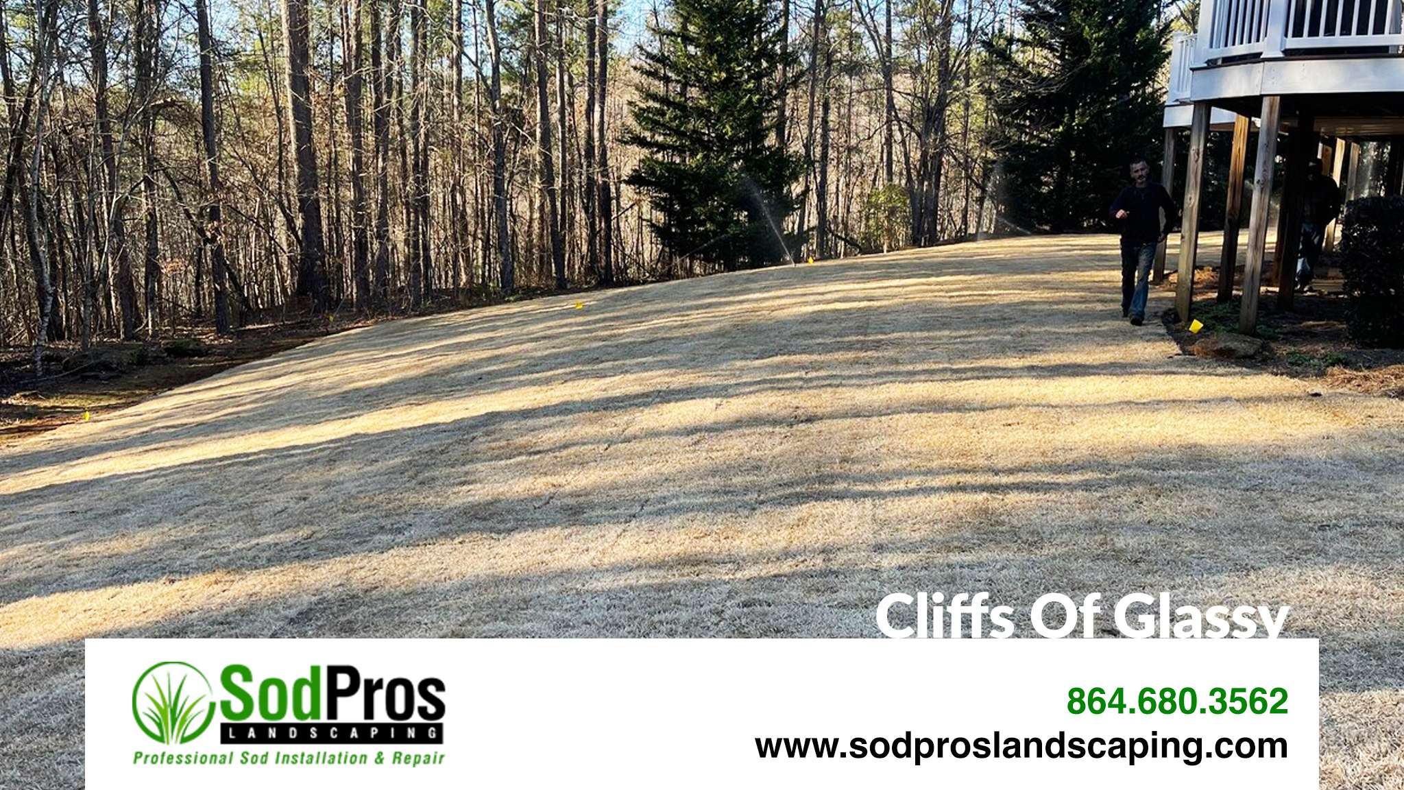 Sod installation area at Cliffs of Glassy, featuring a freshly prepared lawn and wooded background, with a person walking in the scene, showcasing professional landscaping services by Sod Pros Landscaping.